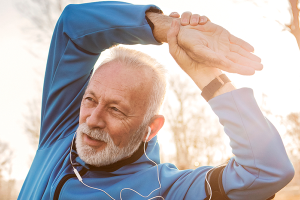 Senior runner doing stretching on a cold winter morning